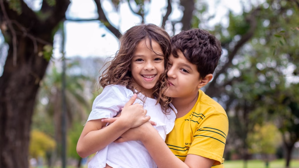 School-age boy hugging his sister in a warm, genuine moment of sibling connection